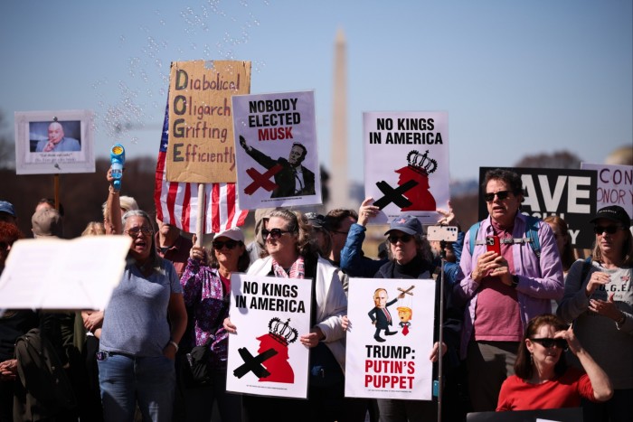 Demonstrators at the White House hold signs says ‘Trump - Putin’s puppet’, ‘No kings in America’ and ‘Nobody elected Musk’