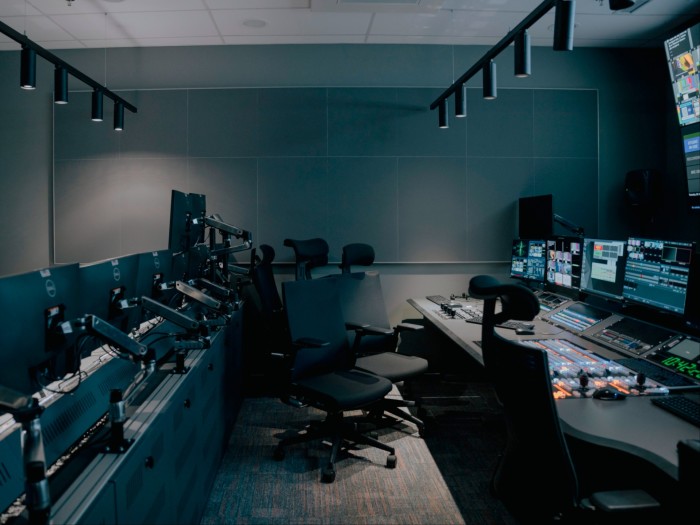 An empty studio featuring chairs and banks of computers
