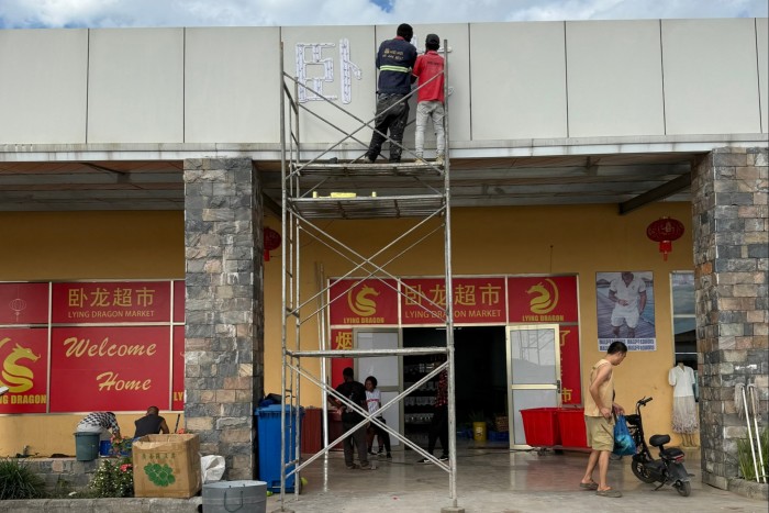 Workers on scaffolding outside Lying Dragon supermarket in Ndola, Zambia
