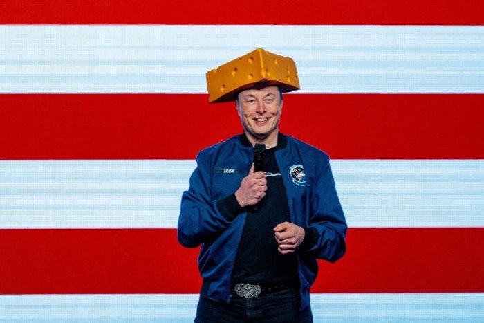 Elon Musk, chief executive officer of Tesla Inc., wears a cheese head hat during an America PAC town hall
