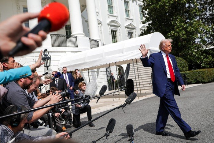 US President Donald Trump waves as he walks to board Marine One, while departing the White House