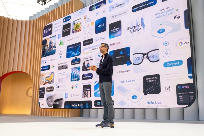Sundar Pichai stands on stage in front of a huge presentation screen