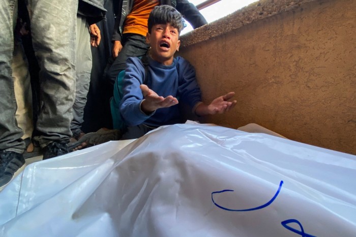 Palestinians mourn by the bodies of relatives who were killed by Israeli fire as they gathered near a US-backed aid centre, at the Nasser hospital in the southern Gaza Strip on June 3