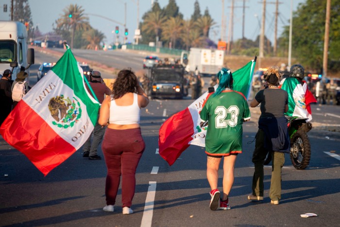 Demonstrators waving Mexican flags face off against law enforcement in Compton